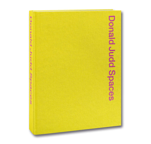 Open page from Donald Judd Spaces art book by Judd Foundation, featuring photographs and illustrations of Judd's minimalist designs.